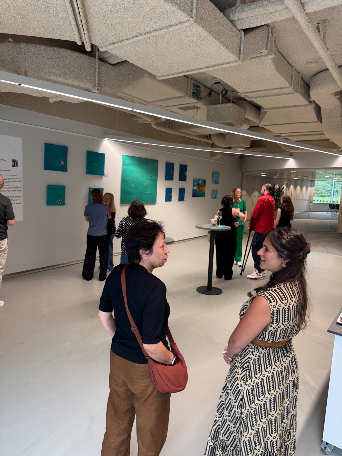 Guests viewing the Lost in the Moments paintings during the exhibition opening