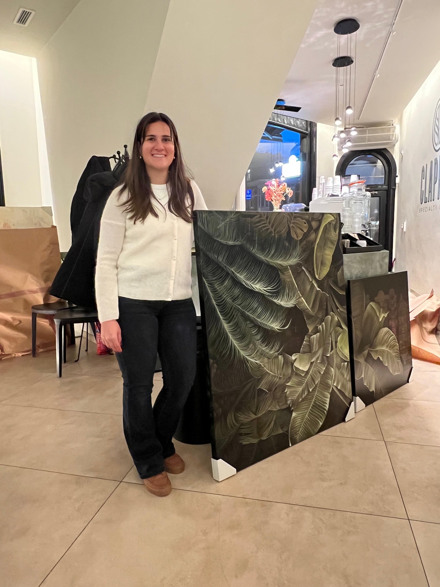 Ecem Naz Ust with her paintings at Clapham Specialty Coffee